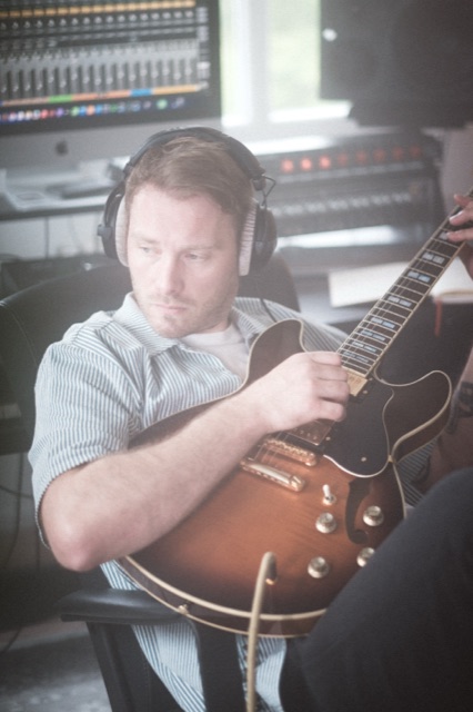 Phil Young mit Kopfhörern spielt eine Yamaha SA2200 vor dem Bildschirm.